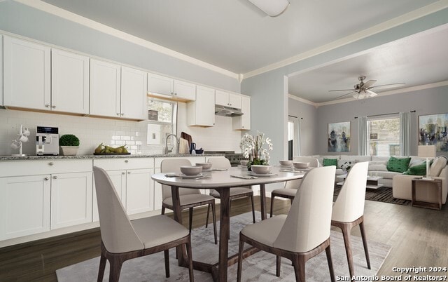 dining area with dark hardwood / wood-style floors, ceiling fan, ornamental molding, and sink