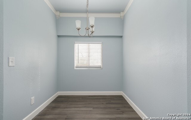 spare room featuring a chandelier and dark hardwood / wood-style floors