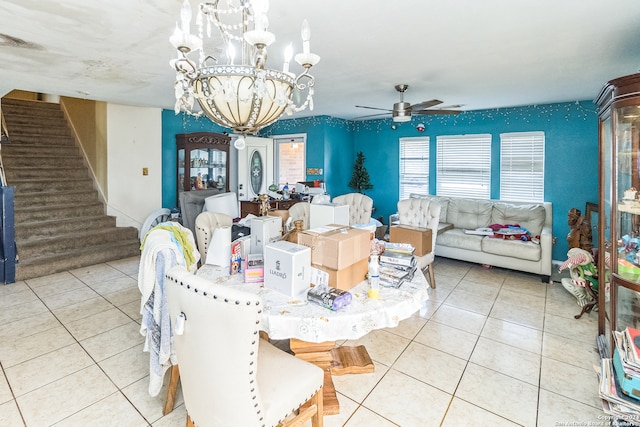 tiled dining area with ceiling fan with notable chandelier