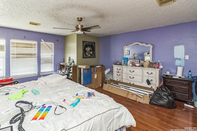 bedroom featuring a textured ceiling, ceiling fan, and dark hardwood / wood-style floors