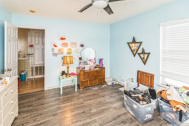 misc room with a textured ceiling, dark hardwood / wood-style flooring, and ceiling fan