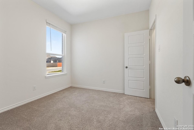 empty room featuring plenty of natural light and light colored carpet