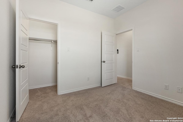 unfurnished bedroom with a closet and light carpet