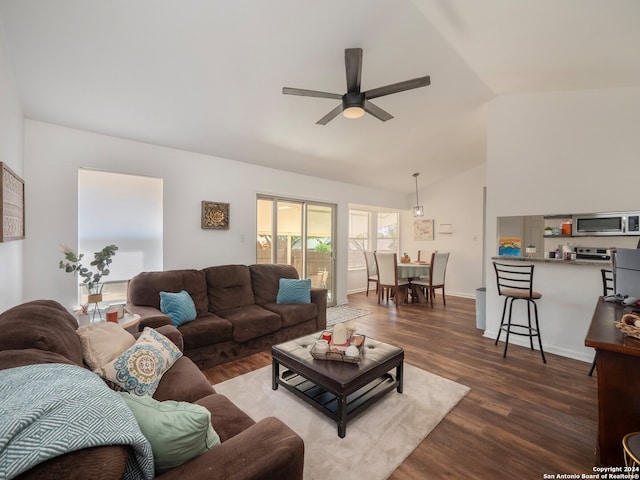 living room with ceiling fan, dark hardwood / wood-style floors, and vaulted ceiling