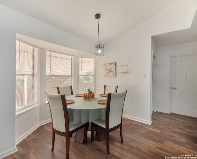 dining room with dark hardwood / wood-style flooring, lofted ceiling, and a wealth of natural light