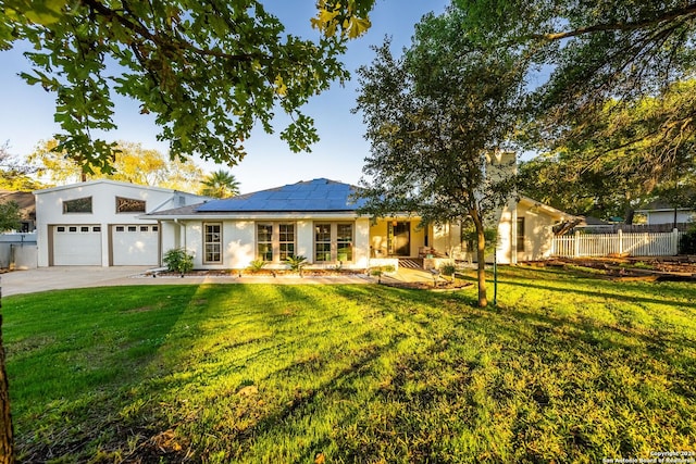 view of front of property featuring solar panels, a garage, and a front lawn