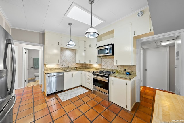 kitchen with white cabinetry, hanging light fixtures, stainless steel appliances, backsplash, and crown molding