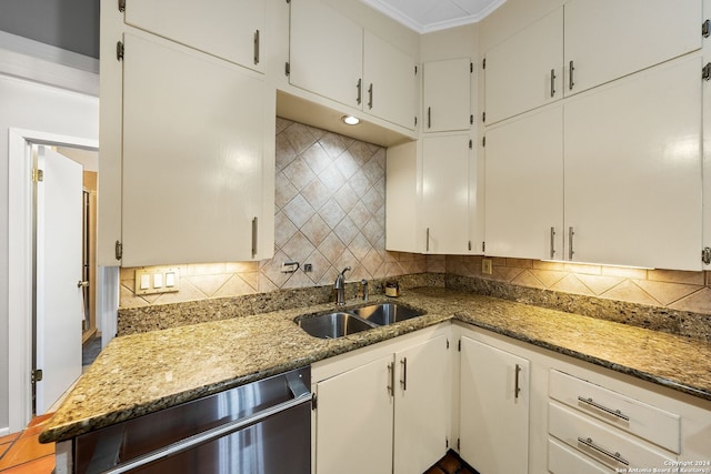 kitchen featuring light stone countertops, backsplash, white cabinets, and sink