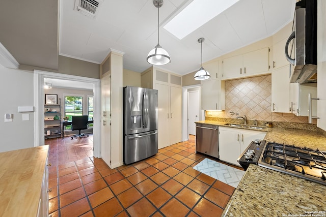 kitchen with appliances with stainless steel finishes, backsplash, sink, decorative light fixtures, and white cabinets