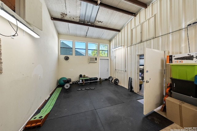 exercise area with cooling unit and high vaulted ceiling