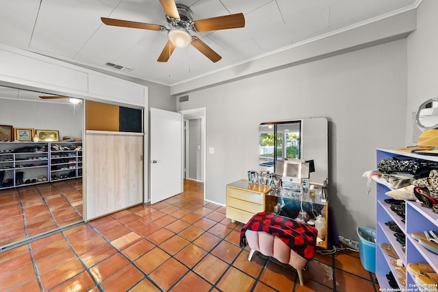 interior space with tile patterned floors, ceiling fan, and ornamental molding