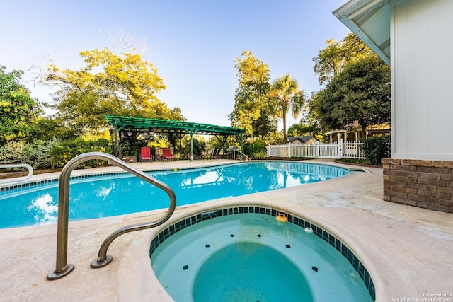 view of pool with an in ground hot tub and a pergola