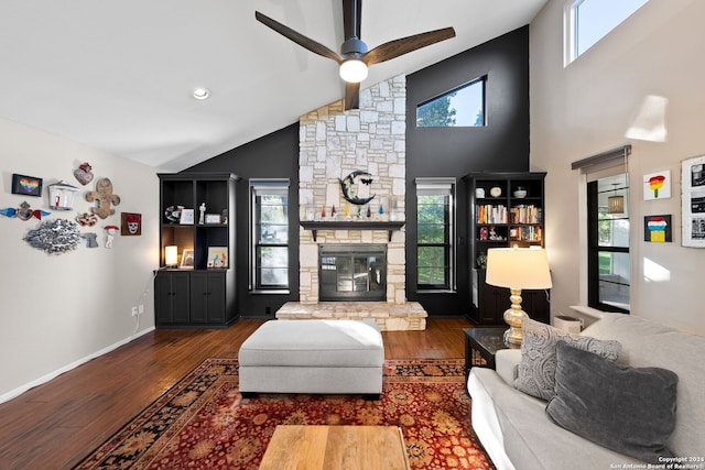 living room with a stone fireplace, ceiling fan, high vaulted ceiling, and dark wood-type flooring