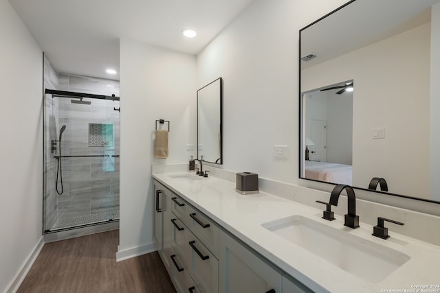 bathroom with hardwood / wood-style floors, vanity, and a shower with door