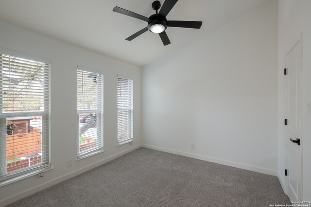 spare room with ceiling fan, plenty of natural light, and carpet floors