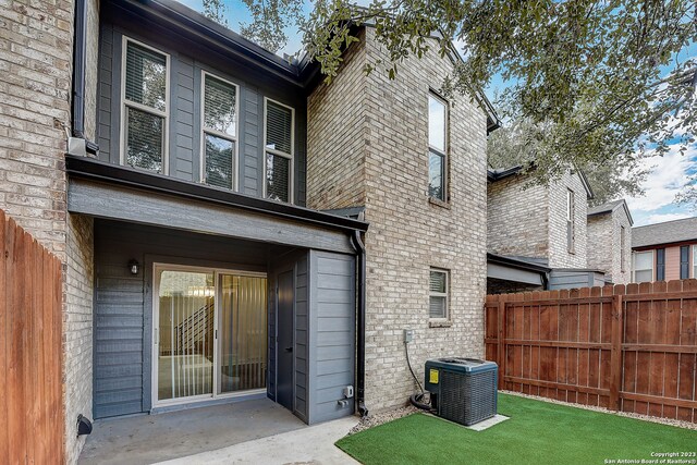 rear view of property featuring central AC