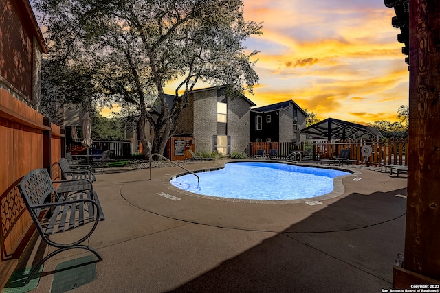 pool at dusk with a patio