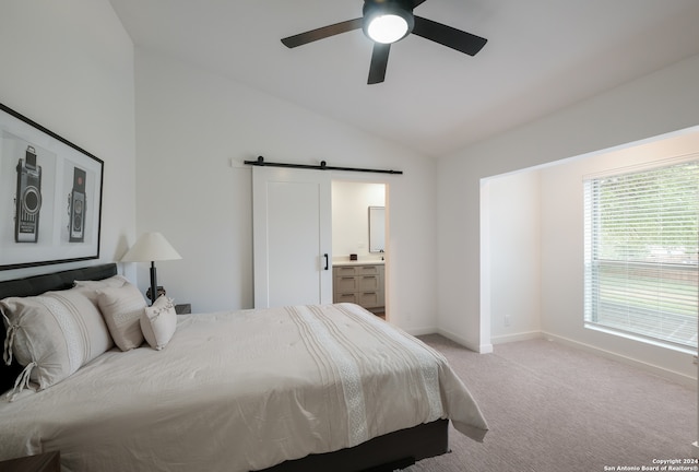 bedroom with connected bathroom, ceiling fan, a barn door, lofted ceiling, and light carpet