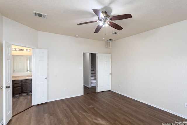 unfurnished bedroom with connected bathroom, ceiling fan, dark wood-type flooring, and a textured ceiling