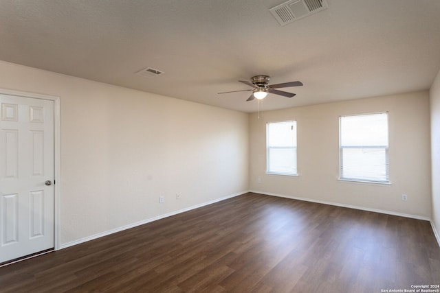 unfurnished room with a textured ceiling, ceiling fan, and dark wood-type flooring