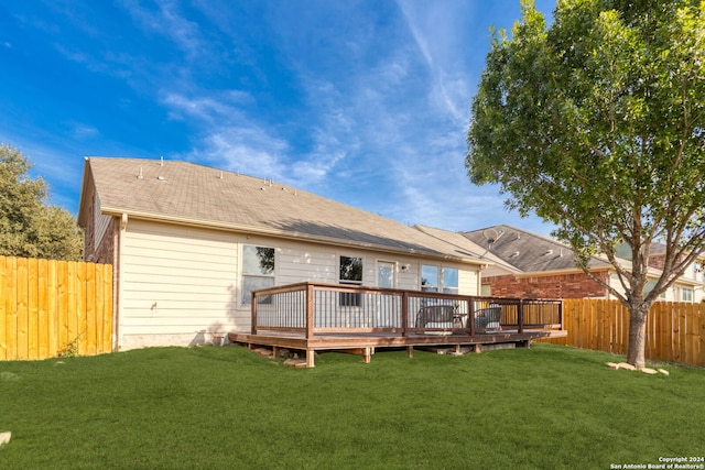 rear view of house with a yard and a wooden deck