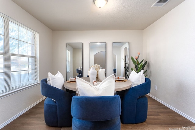 dining room featuring a textured ceiling and dark wood-type flooring