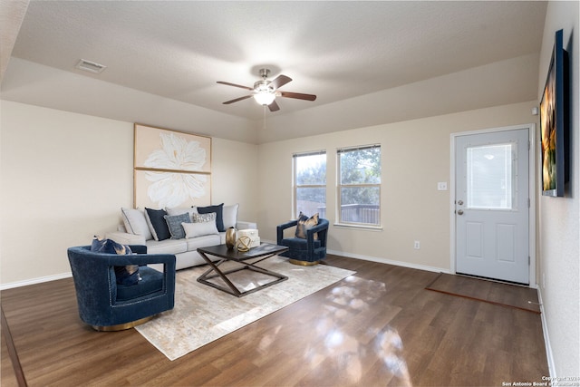 living room featuring ceiling fan, dark hardwood / wood-style flooring, and a textured ceiling