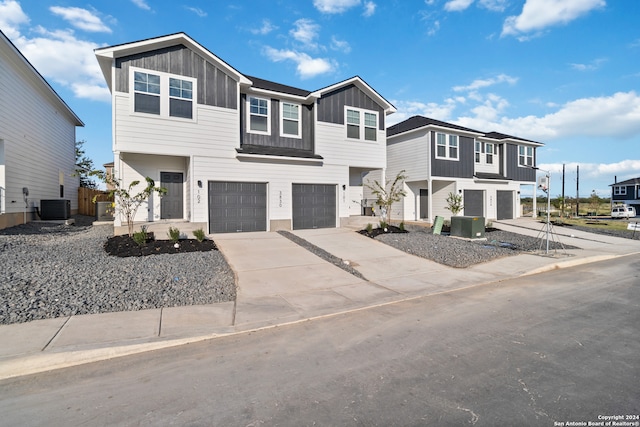 view of front of home with central AC unit and a garage