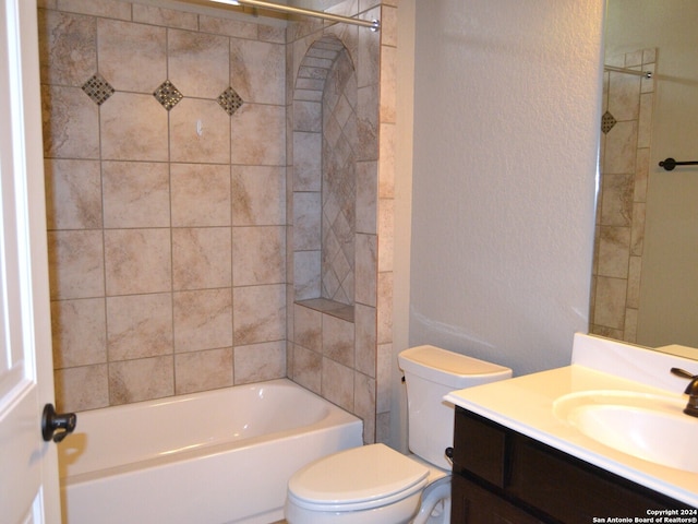 full bathroom featuring vanity, tiled shower / bath, and toilet