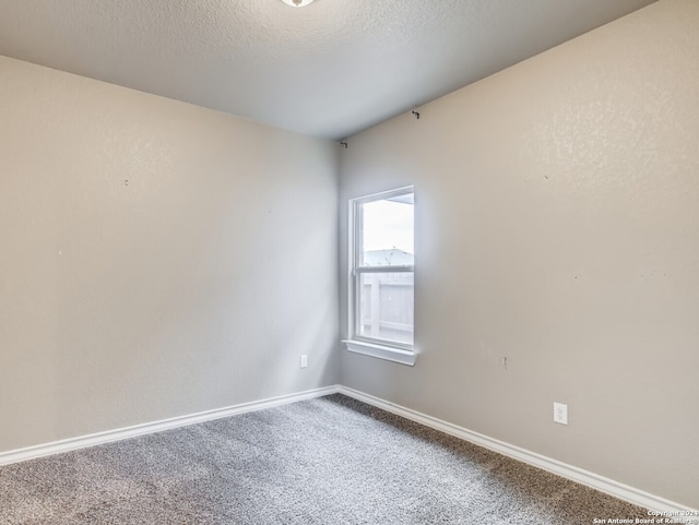 carpeted spare room with a textured ceiling