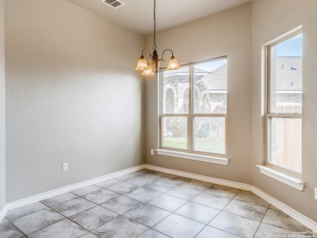 unfurnished dining area with light tile patterned floors and an inviting chandelier