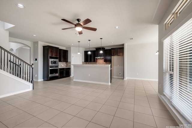 kitchen featuring appliances with stainless steel finishes, backsplash, dark brown cabinetry, ceiling fan, and light tile patterned floors