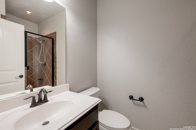 bathroom with vanity, toilet, and a tile shower