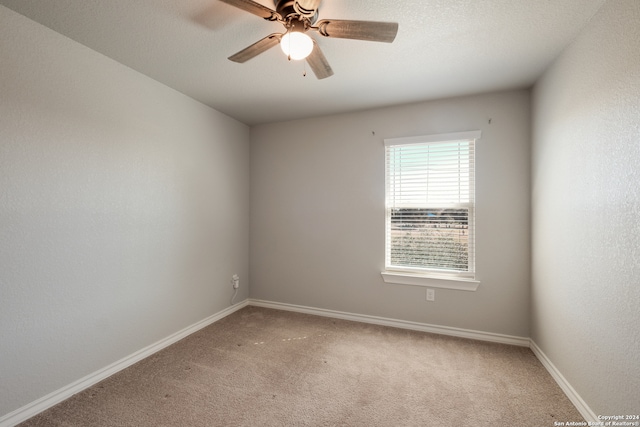 carpeted spare room featuring a textured ceiling and ceiling fan