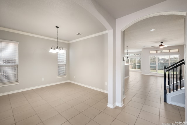 tiled spare room featuring a textured ceiling, ceiling fan with notable chandelier, and ornamental molding