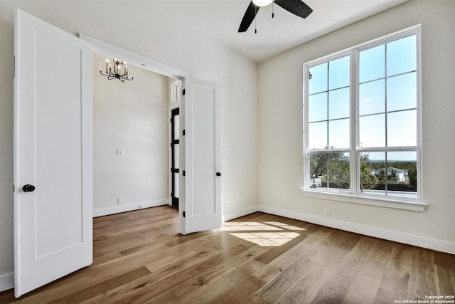 334 Dulce Vis, Boerne, TX 78006 - spare room with wood finished floors, baseboards, ceiling fan, and a chandelier