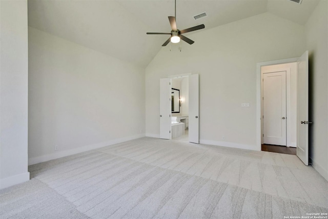 unfurnished bedroom featuring ceiling fan, light colored carpet, ensuite bathroom, and high vaulted ceiling