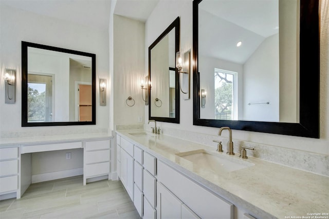 bathroom with lofted ceiling and vanity