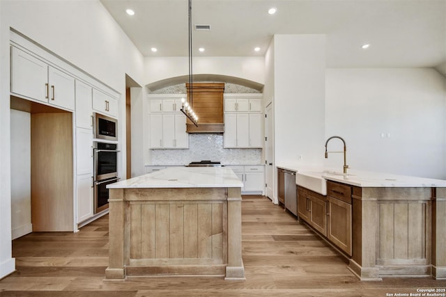 334 Dulce Vis, Boerne, TX 78006 - kitchen featuring a sink, appliances with stainless steel finishes, a center island, arched walkways, and white cabinets