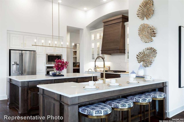 kitchen with decorative backsplash, white cabinetry, hanging light fixtures, and high end refrigerator