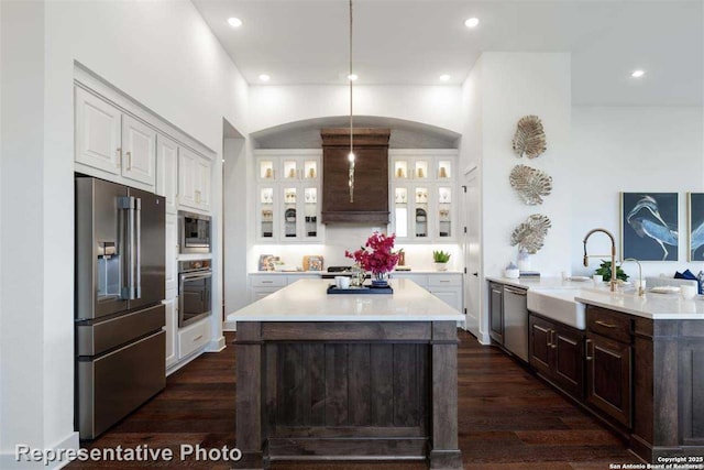 kitchen with white cabinetry, an island with sink, appliances with stainless steel finishes, pendant lighting, and sink