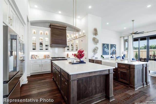 kitchen featuring hanging light fixtures, dark brown cabinetry, stainless steel appliances, and a center island