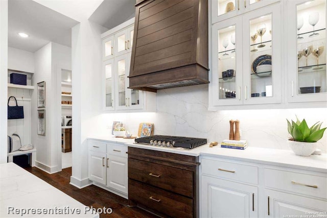 kitchen featuring light stone countertops, white cabinets, dark hardwood / wood-style floors, stainless steel gas stovetop, and custom range hood