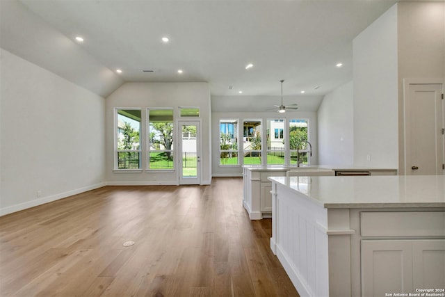 kitchen with ceiling fan, light hardwood / wood-style flooring, white cabinetry, and lofted ceiling