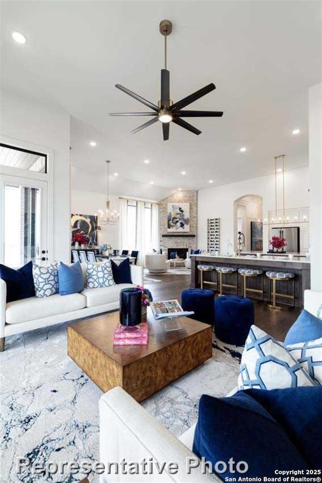 living room with ceiling fan and a fireplace