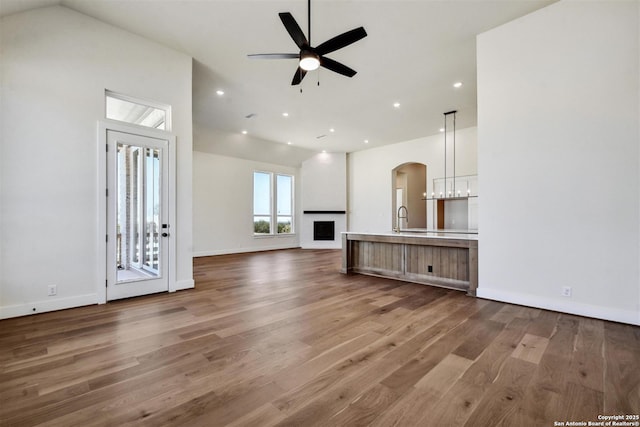 334 Dulce Vis, Boerne, TX 78006 - unfurnished living room with wood finished floors, a ceiling fan, recessed lighting, baseboards, and arched walkways