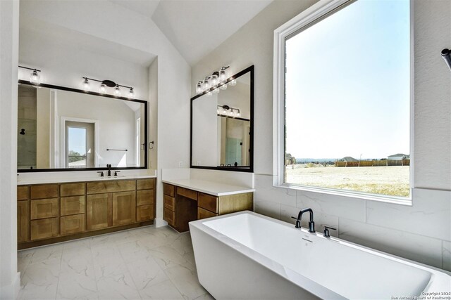 334 Dulce Vis, Boerne, TX 78006 - full bathroom featuring marble look tile flooring, a freestanding tub, vanity, and vaulted ceiling