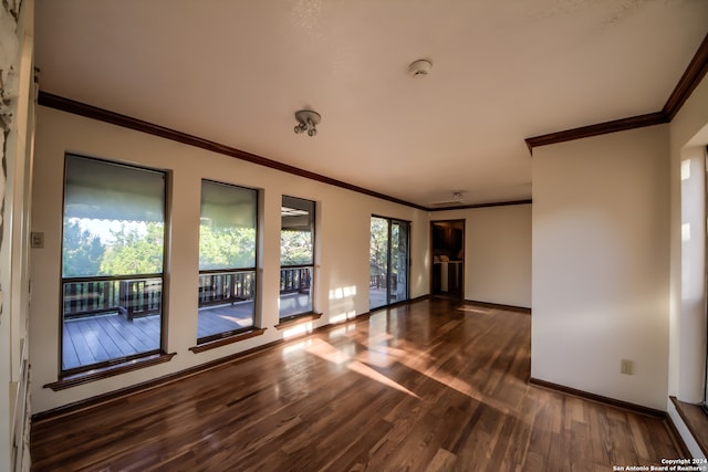 empty room with dark hardwood / wood-style flooring and crown molding