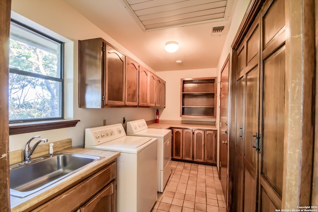 laundry room featuring separate washer and dryer, sink, light tile patterned floors, and cabinets