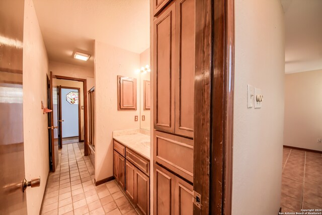 bathroom with tile patterned flooring, vanity, and an enclosed shower